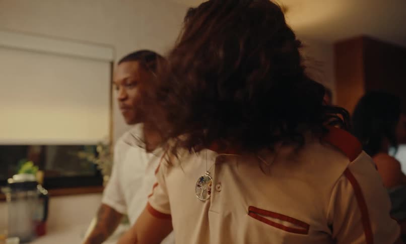 Two happy men talking in the kitchen surrounded by friends