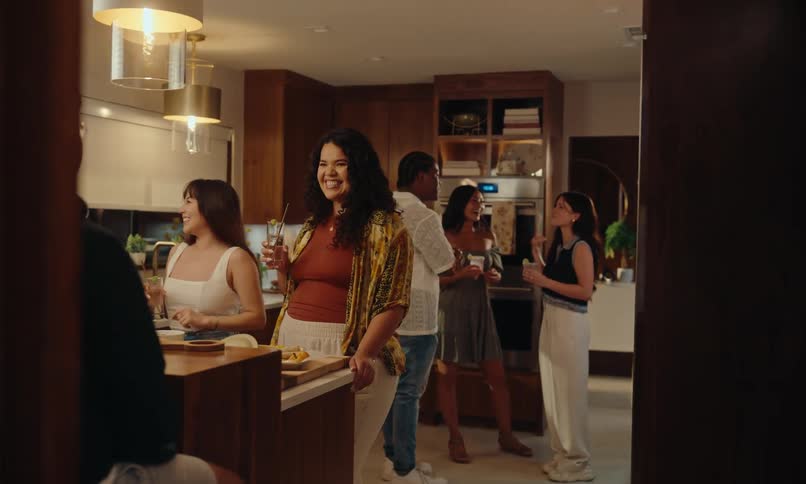 Group of friends talking and drinking in a kitchen at home