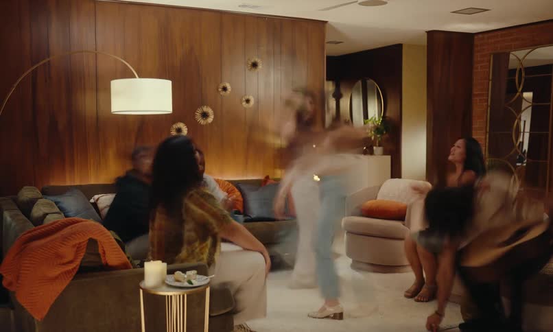 Group of friends playing guitar and dancing in a living room