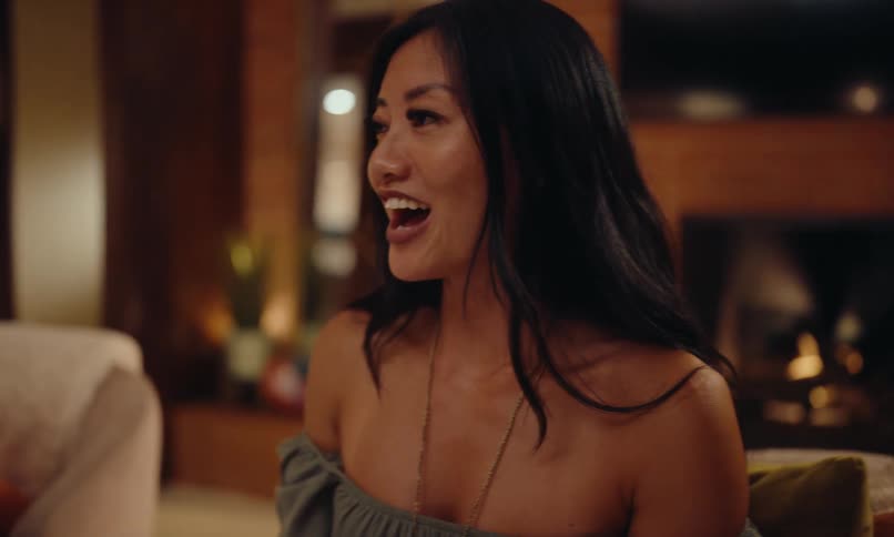 A woman is smiling as she talks