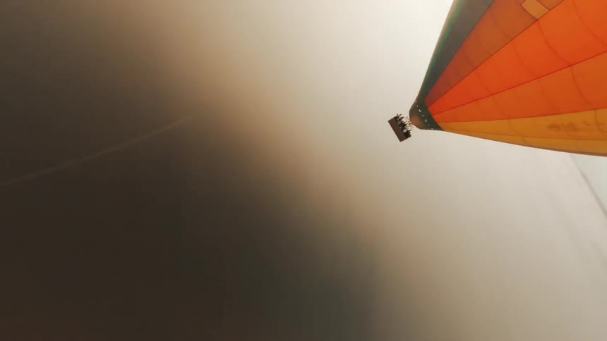 Aerial panorama of a colorful balloon flying above a sea of clouds