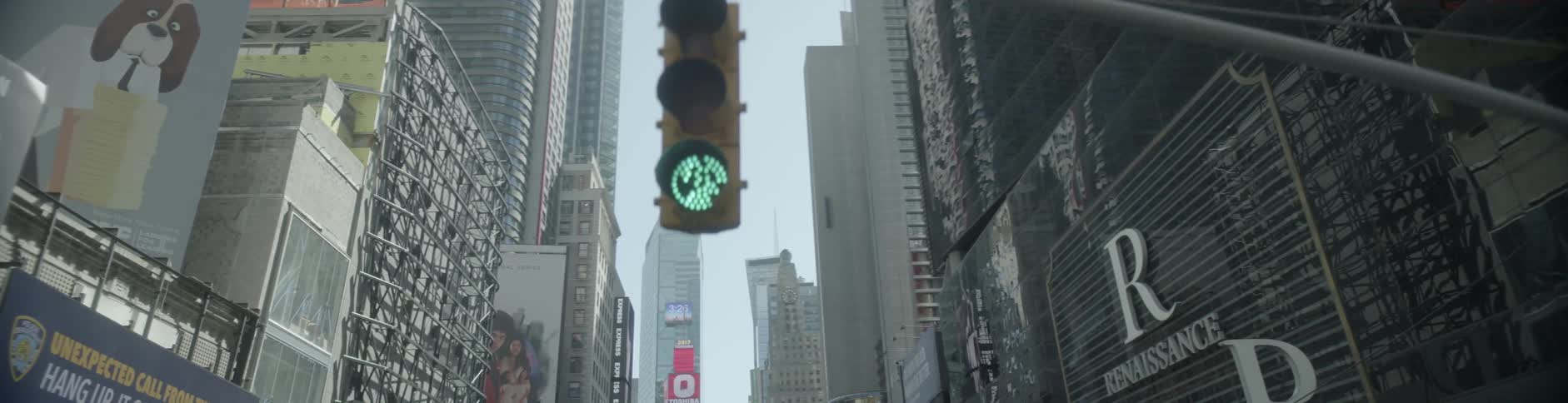 A hanging street light shines green