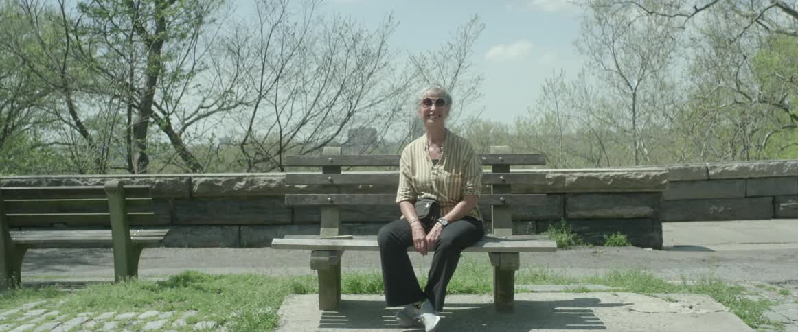A woman sits on a park bench