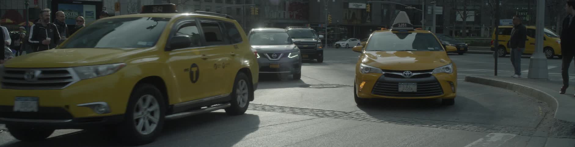 Several cars drive through a city street
