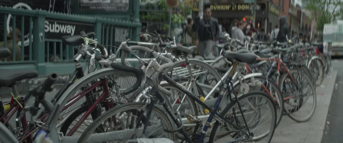 Bicycles parked on a city street in front of subway entrance