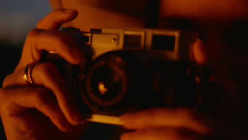 Portrait of a young woman using a vintage camera
