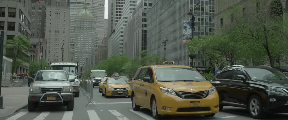 Cars passing a crosswalk on a city street