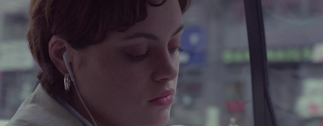 Portrait of a woman with earphones inside a moving car
