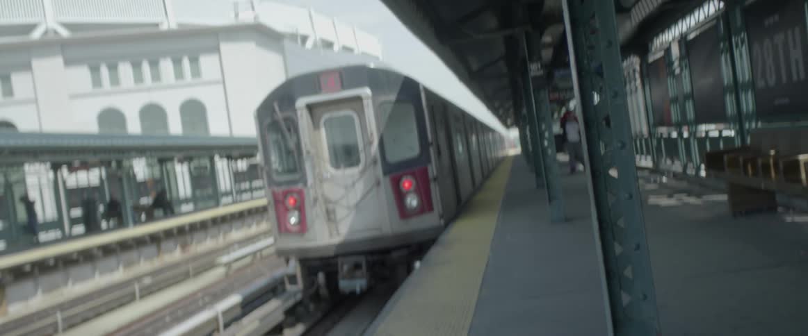 A train passes some people at the station