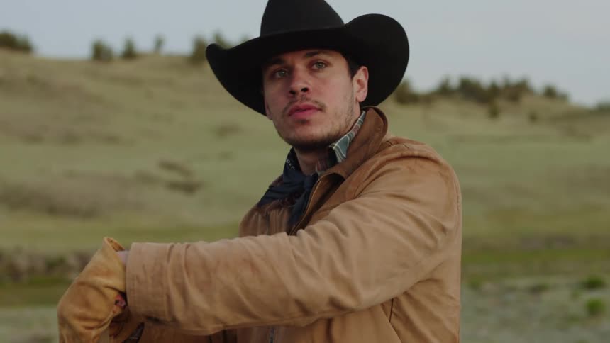 Cowboy with a serious expression using a tool in a natural environment