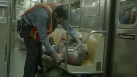 A man waking up a homeless person on a train