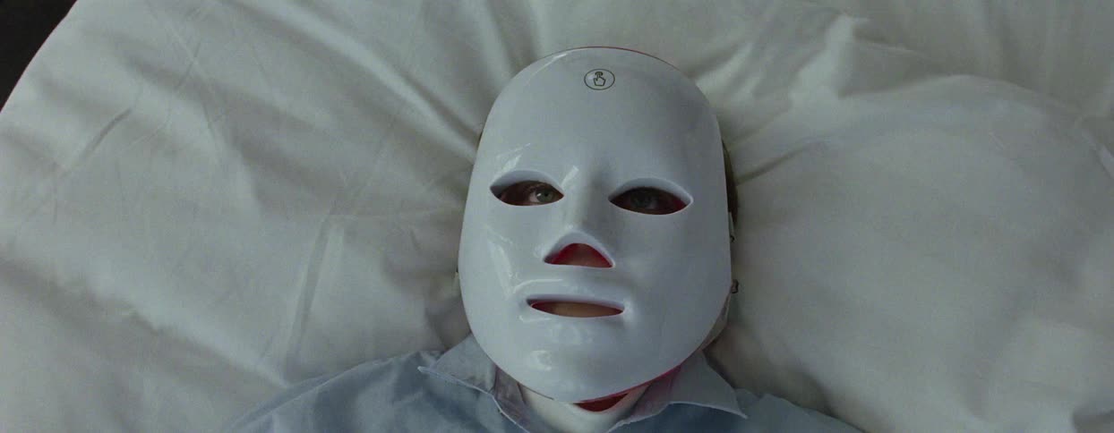 Woman with mask lying on bed