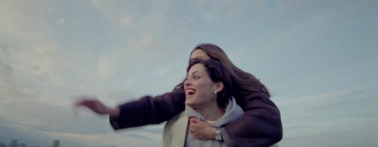 Woman carrying a girl on her back and both are smiling