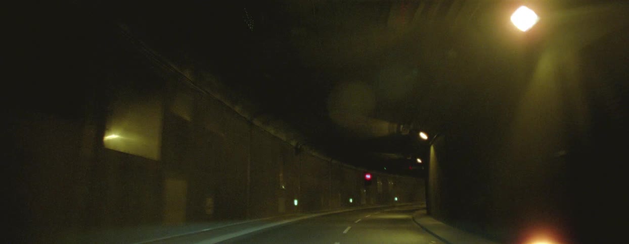 Moving view of a paved highway on an overpass at night
