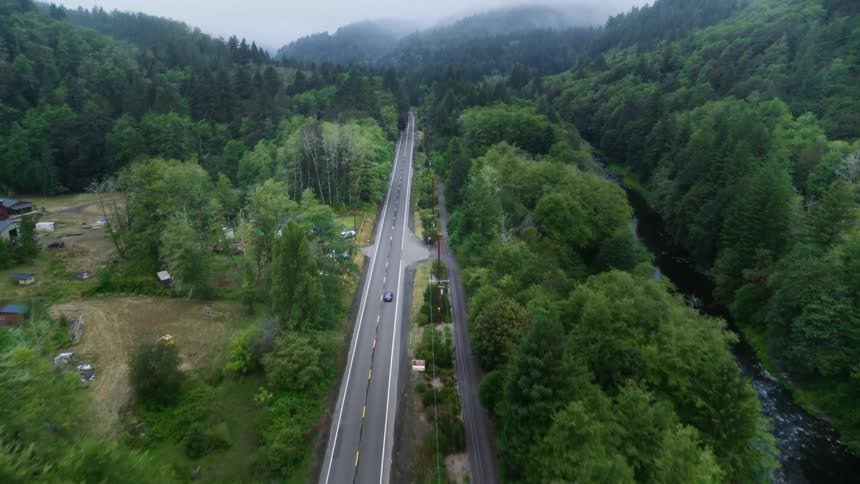 A car driving down a freeway cutting through a forest