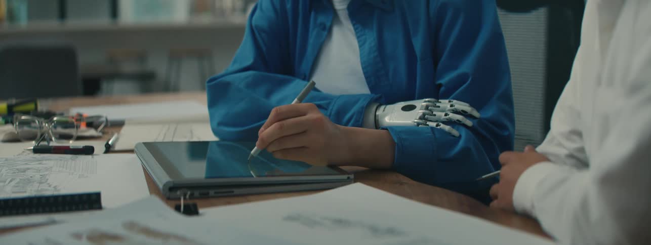 Two peoples hands using a tablet on the table