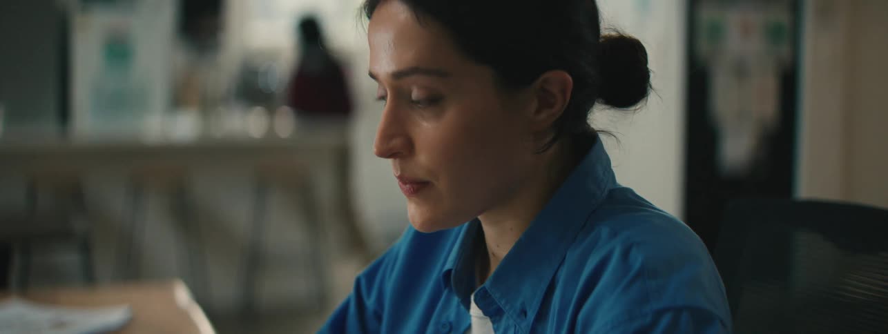 Close up of the face of a woman wearing a blue top