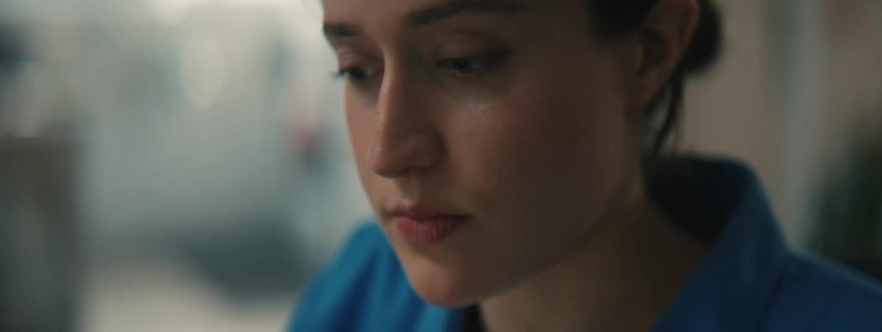 Close up of the face of a woman wearing a blue top