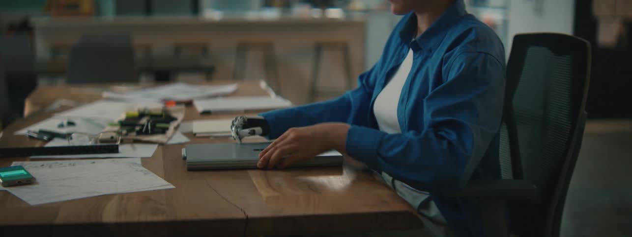 A woman closes her laptop and gets up