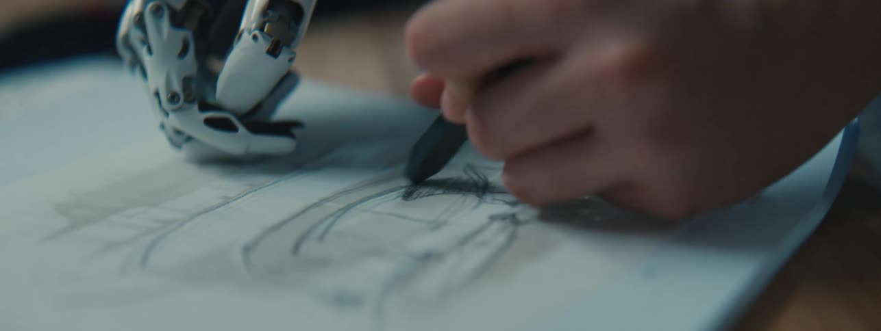 Hand with a pen drawing on a white sheet