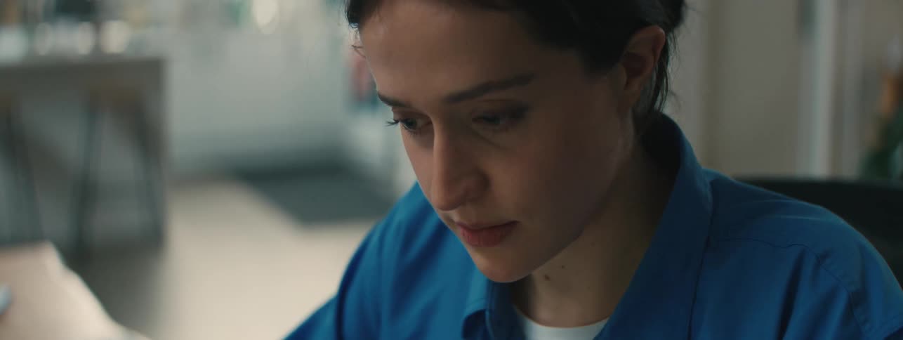 Close up of the face of a woman wearing a blue top