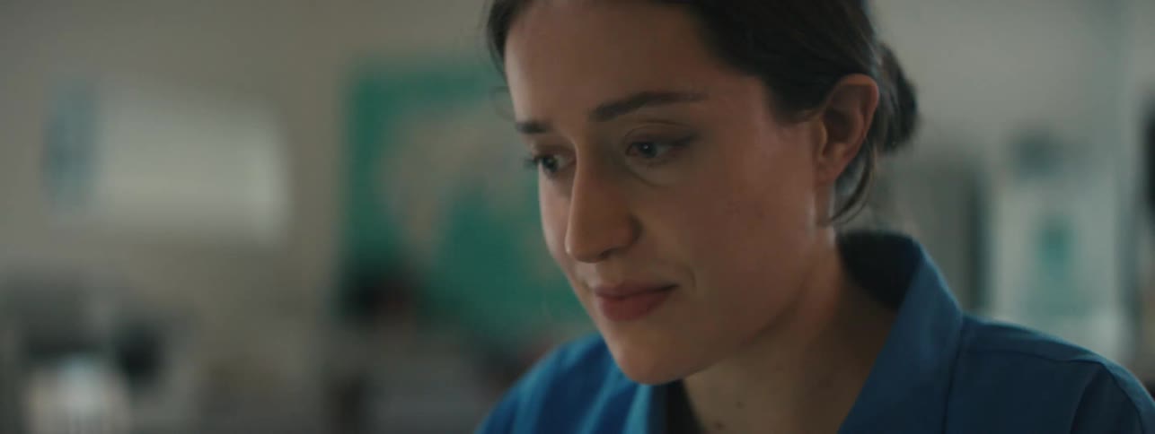 A woman is smiling while looking at something