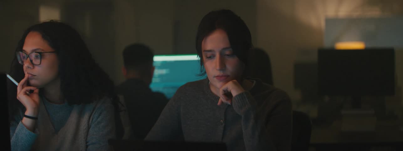 Four people sit in a room working on computers