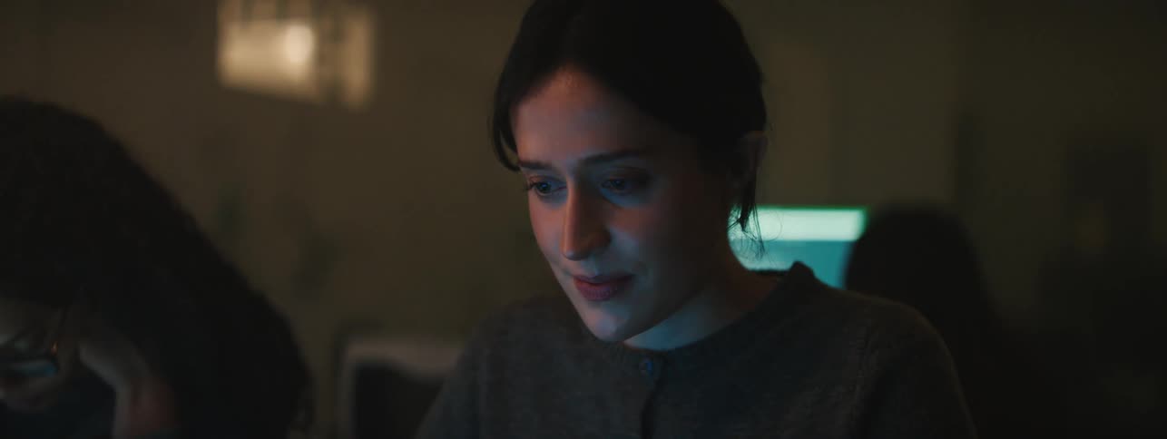 A woman smiling while working on a computer
