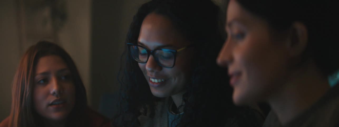 Three women smiling and enjoying a moment together engaged in a conversation
