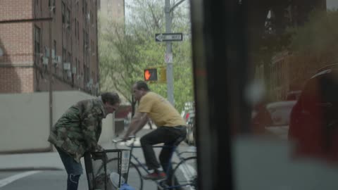 A man rummages through a garbage bin