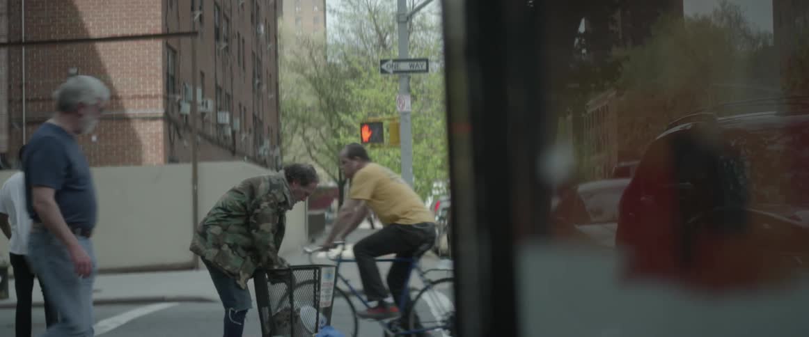 A man rummages through a garbage bin