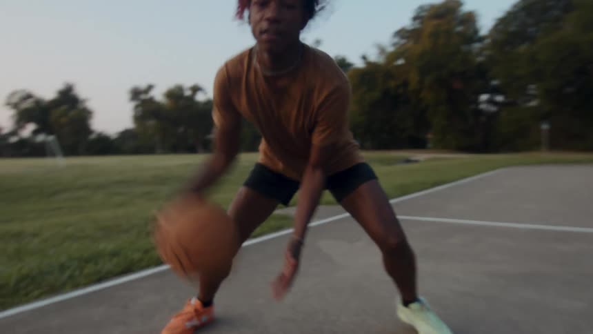 Young man dribbling a basketball on a court