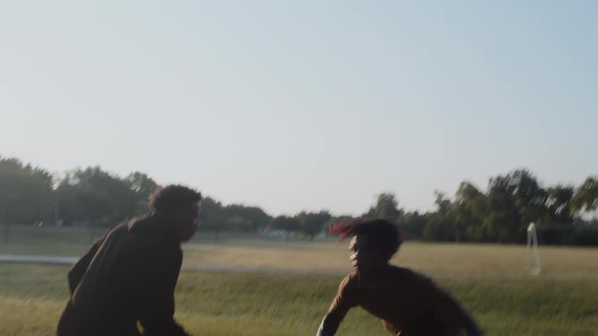 Two boys playing basketball on a court and making a shot
