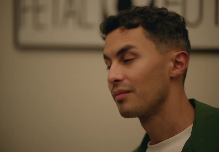 Man listens and then looks down to the left