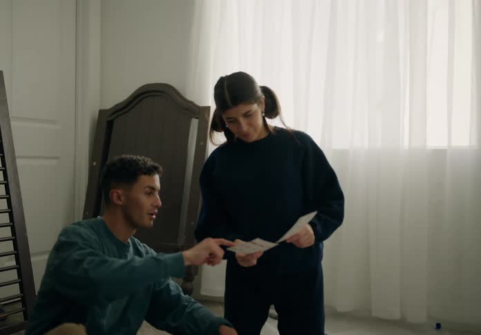 A young couple examines color swatches choosing shades to paint a room in their home