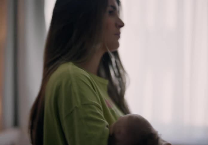 Mother walking around the room with her baby in her arms