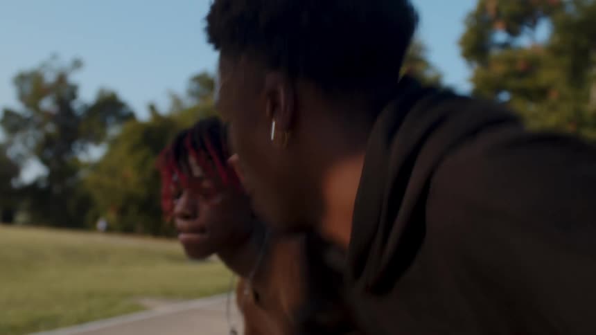 A couple of friends are engaged in a competitive game of basketball on a court at sunset