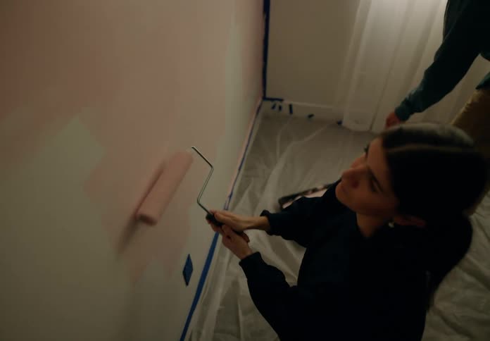 Couple paints a wall pink with rollers