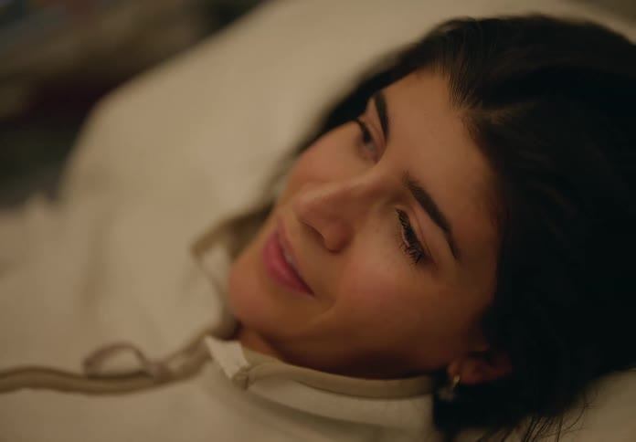 Close up of the face of a woman resting on a bed