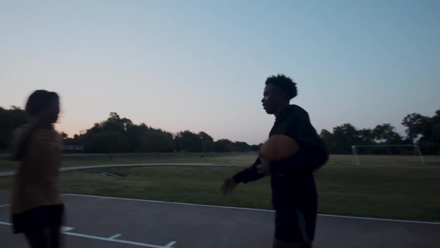 Two men start a game of basketball