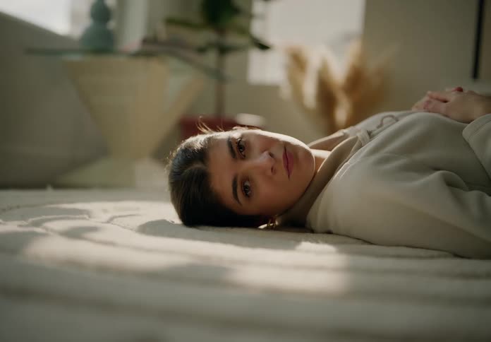 Closeup of a woman resting on the floor in the living room looking at the camera