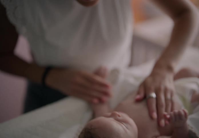 Mother massages her baby