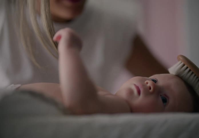 Mother combing her babys hair
