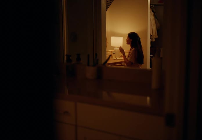 Woman seen in the mirror doing skin care