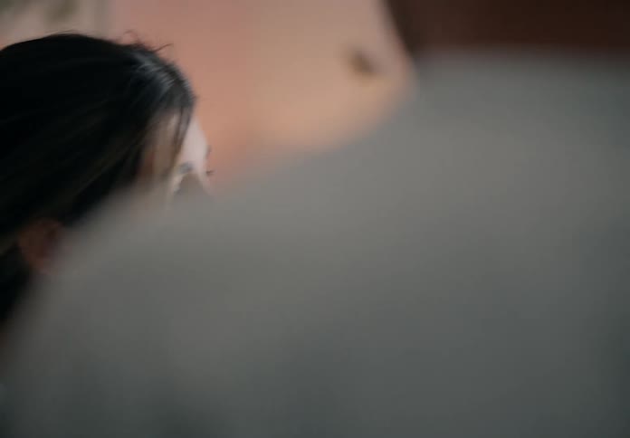A father gently places his newborn son in a crib in the bedroom