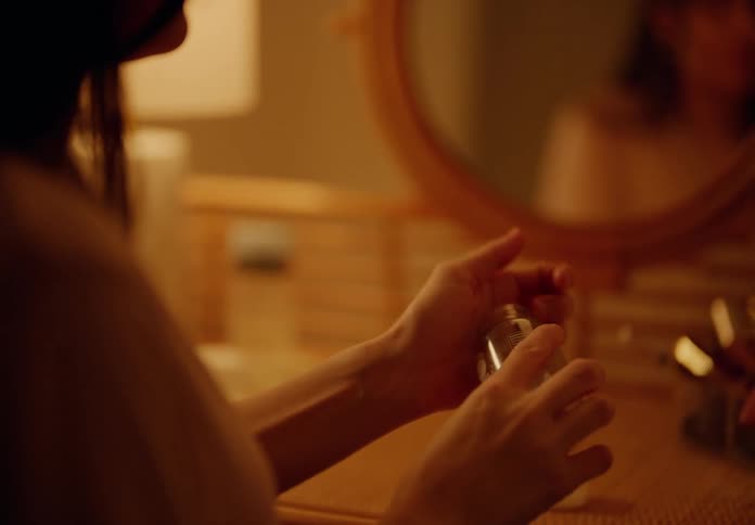 Woman sitting taking a capsule