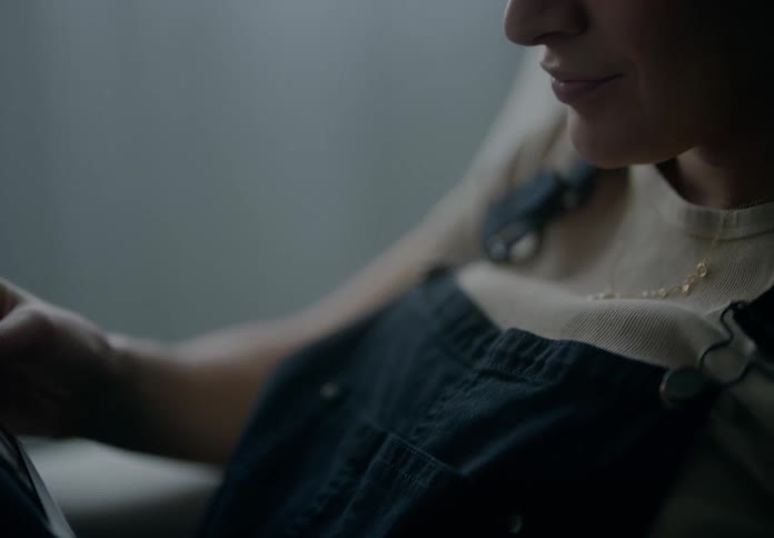 Woman looks at ultrasound photos in a dimly lit room