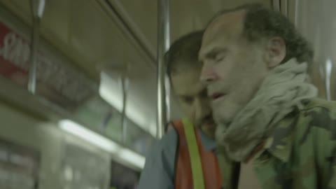 A subway worker helps a man get off the train