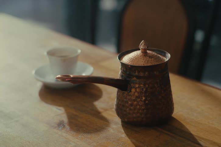 A coffee cup and coffee sit on a table in a cafe
