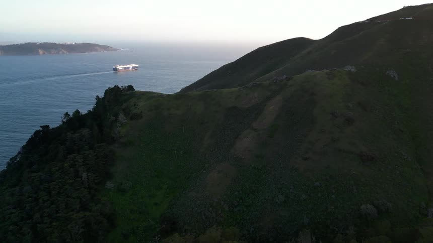 Aerial panorama of a mountainous valley by the sea with a boat in the background
